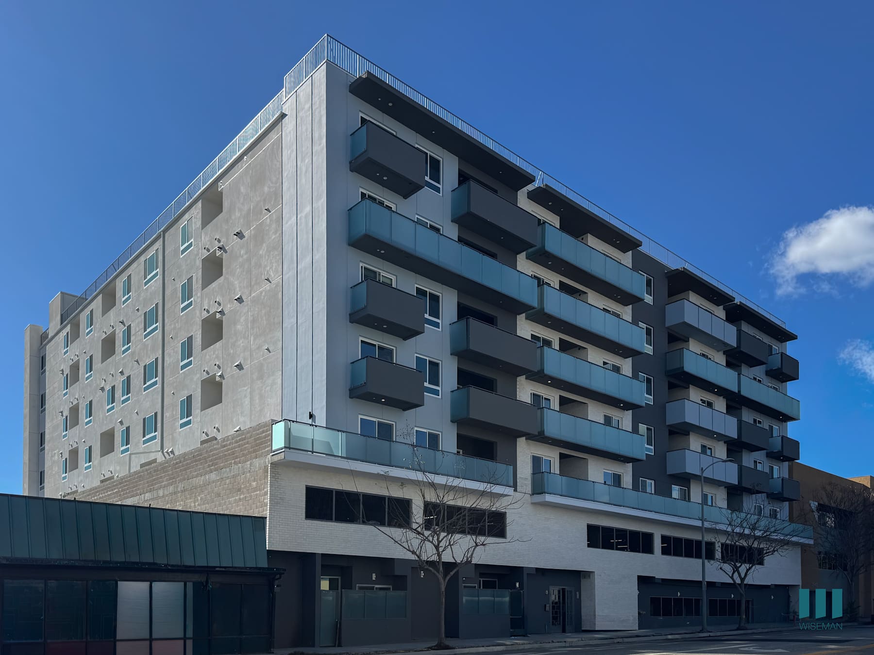 Motor Tides on Motor Avenue, its glass-railed balconies above the street-level frontage